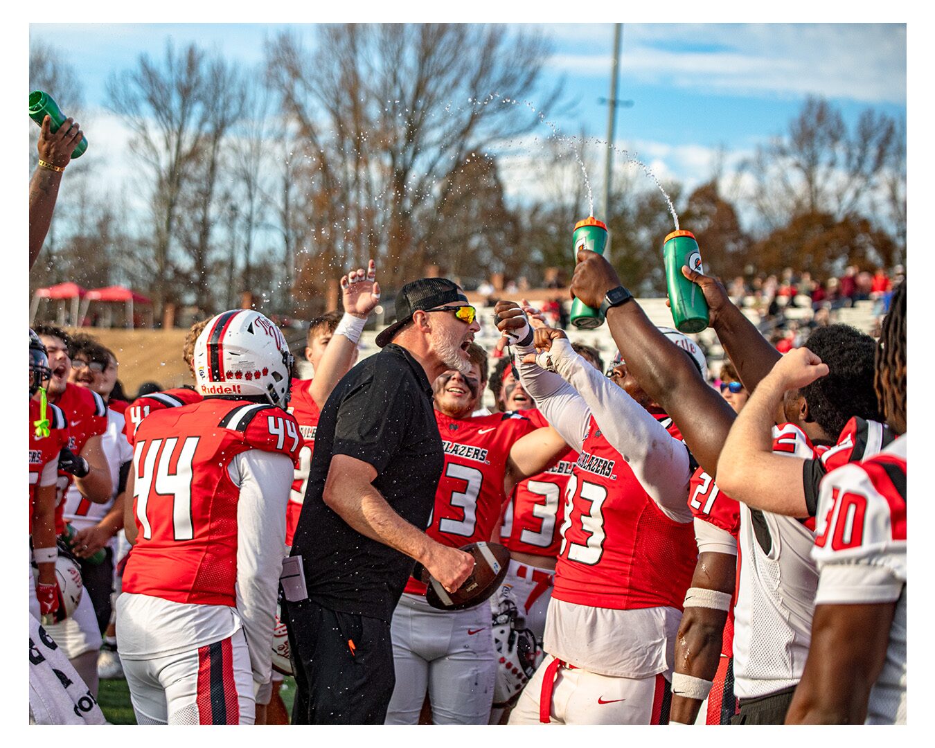 Coach Garner laughing with players after the bowl win. The people you build with.