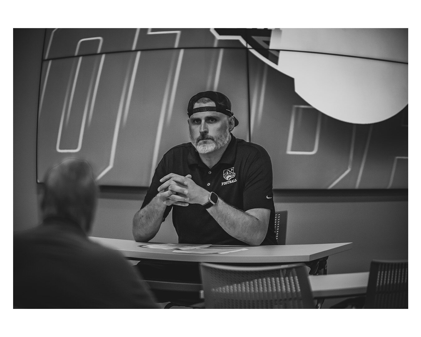 Coach Garner in a film-room conversation, in black and white.